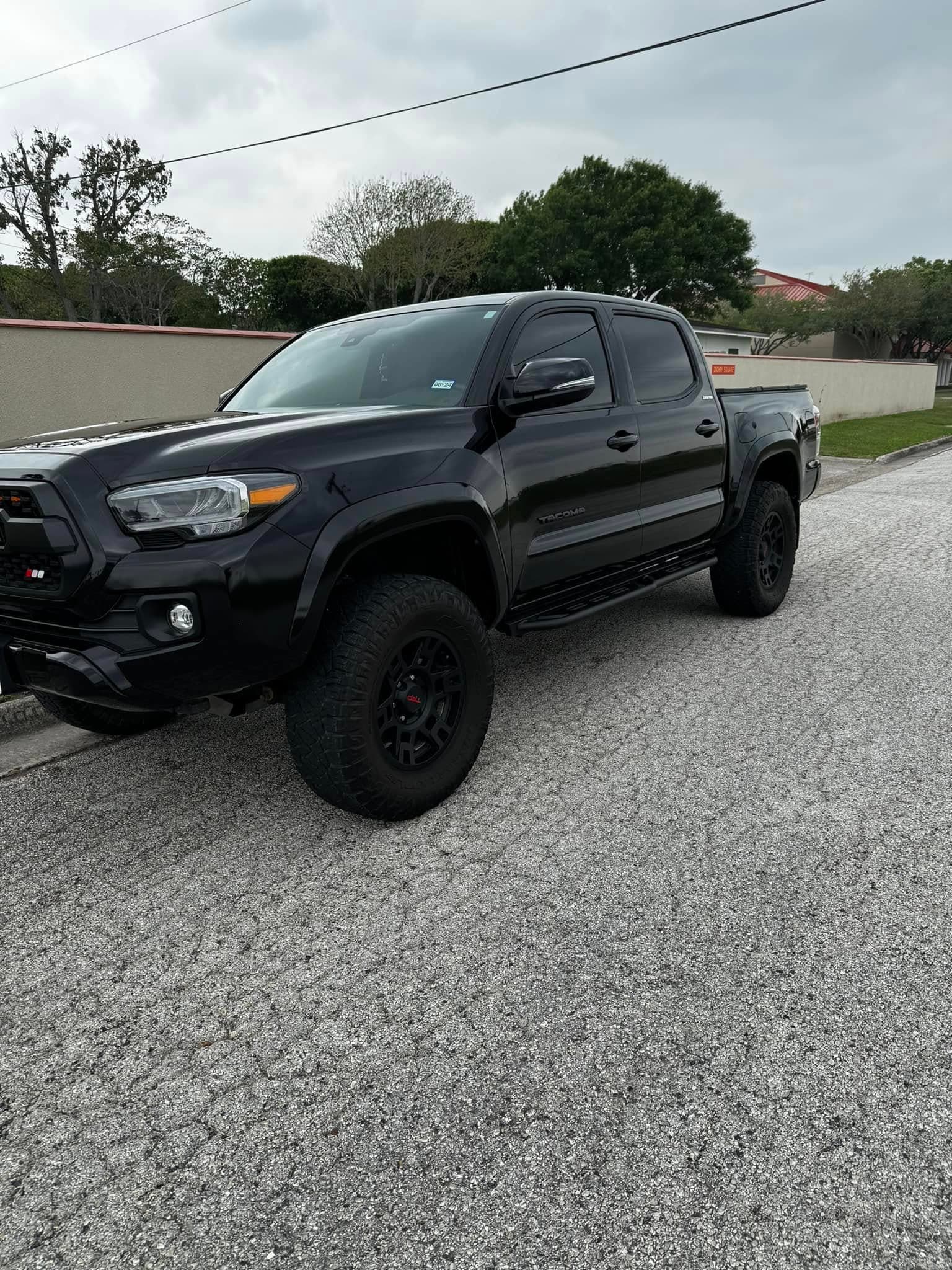 Glossy black Toyota Tacoma with a wet-look finish along every panel
